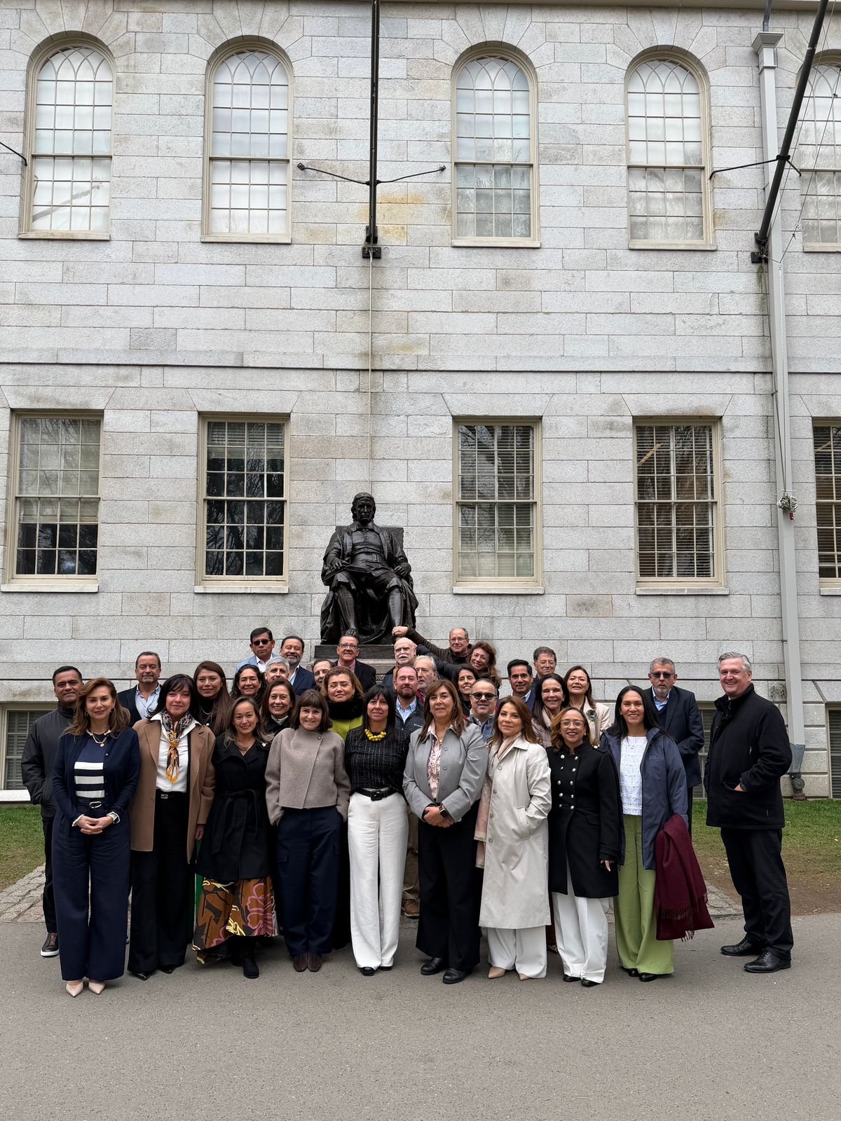 Cohort of Latin American directors at Harvard, in front of the John Harvard statue